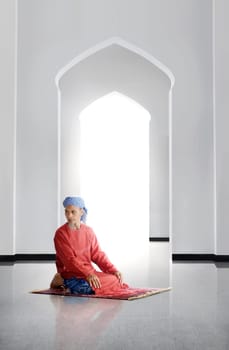 Elderly asian muslim man praying inside the mosque