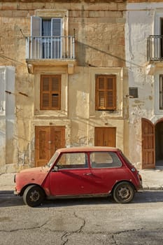 VALLETTA, MALTA - OCTOBER 30, 2017: Old vintage car in front of typical traditional house in Valletta in Malta.