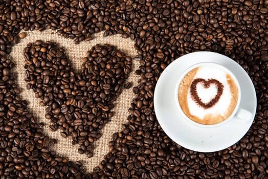 cappuccino with heart on a lot of coffee beans