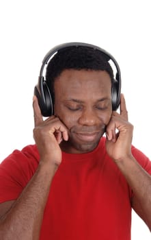 A happy looking African American man with his headphones .on, listening to music in a red t-shirt, isolated for white background.