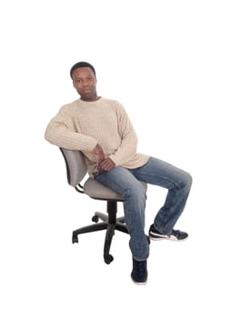 A full body image of a African American man in jeans and beige sweater.sitting on office chair, isolated for white background.