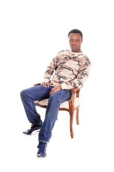 A full body image of a African American man in jeans and t-shirt.sitting on chair and relaxing, isolated for white background.