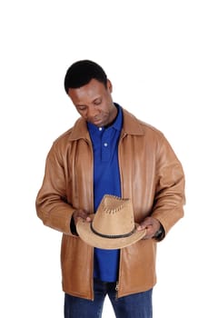 A good looking African American man standing smiling with a hat.and brown leather jacket, isolated for white background.