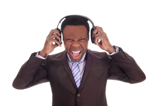 A scared looking African American business man with his headphones .on, listening to music in suit and tie, isolated for white background.