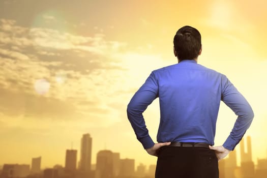 Back view of businessman looking at sunset view on the city