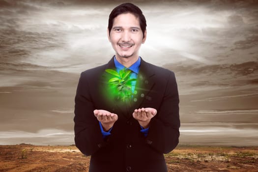 Handsome asian businessman holding plant with climate change background