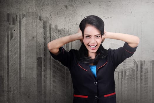 Pretty asian business woman covering her ears over abstract background