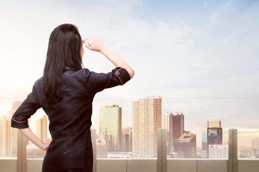 Young asian business woman looking at cityscape from terrace