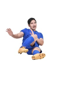 Images of asian male soccer player doing sliding tackle isolated over white background