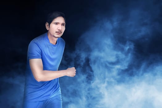 Handsome asian soccer player man with blue jersey over abstract background