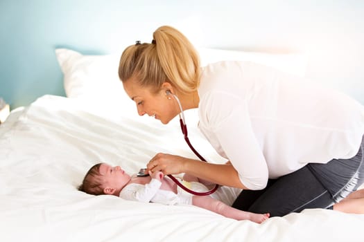 Pediatrician examines baby with stethoscope at home