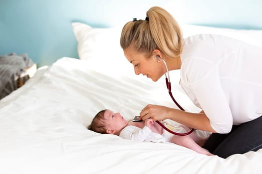 Pediatrician examines baby with stethoscope at home