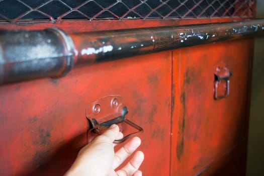 Hand on red metal antique distressed cabinet, stock photo