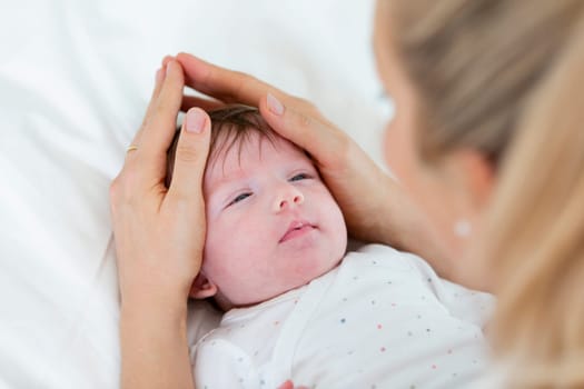 beautiful blond mother, woman massages her baby