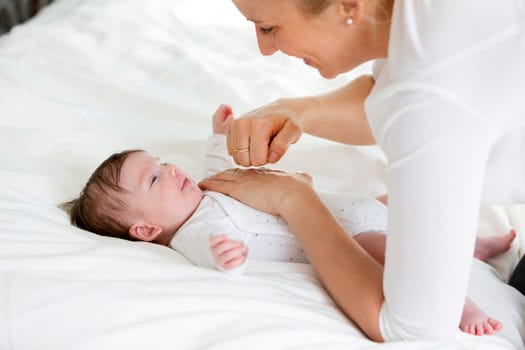 beautiful blond mother, woman massages her baby