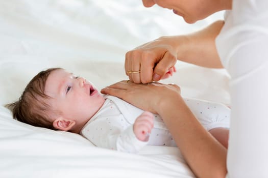 beautiful blond mother, woman massages her baby