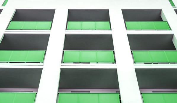 White living house with appartments and green balconies