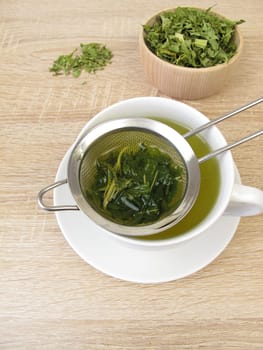 Freshly brewed hemp tea in a tea strainer