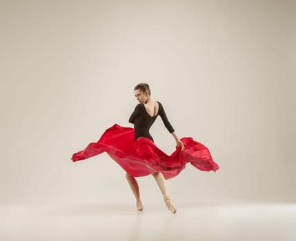 Modern ballet dancer exercising in full body on white studio background. Ballerina or female dancer with silk fabric dancing on white studio background. Caucasian model on pointe shoes