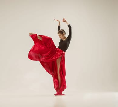 Modern ballet dancer exercising in full body on white studio background. Ballerina or female dancer with silk fabric dancing on white studio background. Caucasian model on pointe shoes