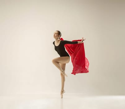 Modern ballet dancer exercising in full body on white studio background. Ballerina or female dancer with silk fabric dancing on white studio background. Caucasian model on pointe shoes
