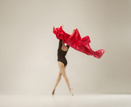 Modern ballet dancer exercising in full body on white studio background. Ballerina or female dancer with silk fabric dancing on white studio background. Caucasian model on pointe shoes