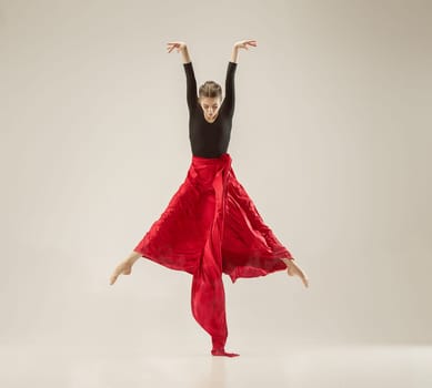 Modern ballet dancer exercising in full body on white studio background. Ballerina or female dancer with silk fabric dancing on white studio background. Caucasian model on pointe shoes