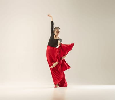 Modern ballet dancer exercising in full body on white studio background. Ballerina or female dancer with silk fabric dancing on white studio background. Caucasian model on pointe shoes