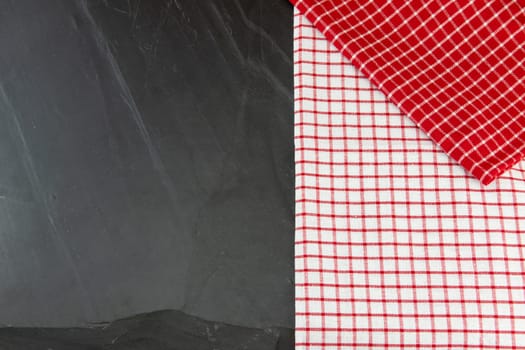 Red and white checkered tablecloth on massive slate plate. Template for design menu card and chalkboard. Space for designer.