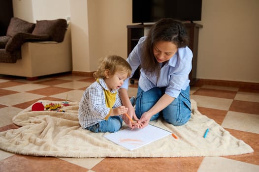 A mother and her young child spend quality time drawing together, fostering imagination and creativity, while enjoying a warm and supportive atmosphere in a comfortable home setting.