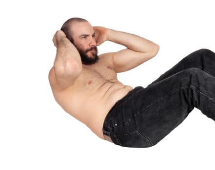 A slim handsome man without a shirt and in jeans doing stomach.crunches on the floor, isolated for white background.