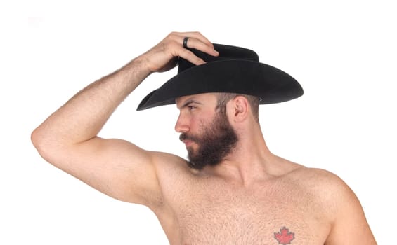 Young man standing shirtless, wearing a black cowboy hat .with his muscular body and a beard, isolated for white background.