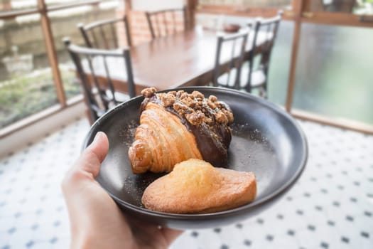 People hand hold plate serving fresh baked bakery, stock photo