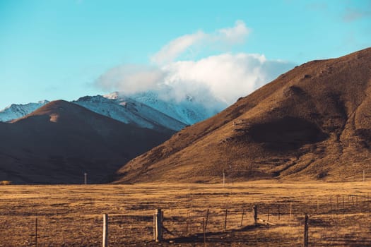 Road travel in the green mountains of New Zealand view from car window. Scenic peaks and ridges. Beautiful background of amazing nature.