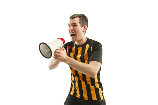 The young Belgian fan celebrating on white background. The young man in soccer football uniform screaming in megaphone isolated at white studio. Fan, support concept. Human emotions concept.