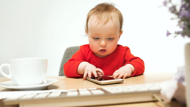 Hard day. child baby girl sitting with keyboard of modern computer or laptop in white studio background. early development of modern kids concept. Businesswoman, lady boss and girl-boss concepts