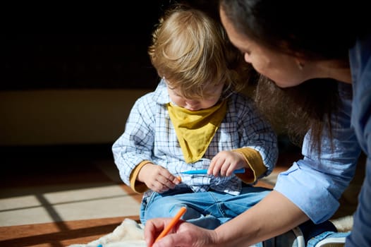 A young child engaged in an activity, accompanied by their mother, creating a warm and intimate atmosphere filled with love and support.
