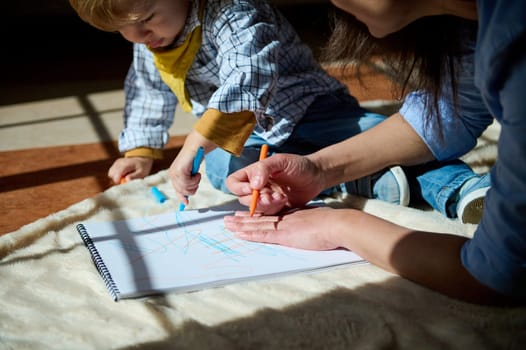 A mother and her young child engage in a creative coloring activity together, enjoying quality time and fostering a special bond, in a beautifully sunlit space.