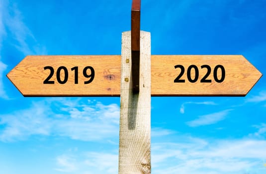 Blank wooden signpost with two arrows over clear blue sky with copy space, just add your text here