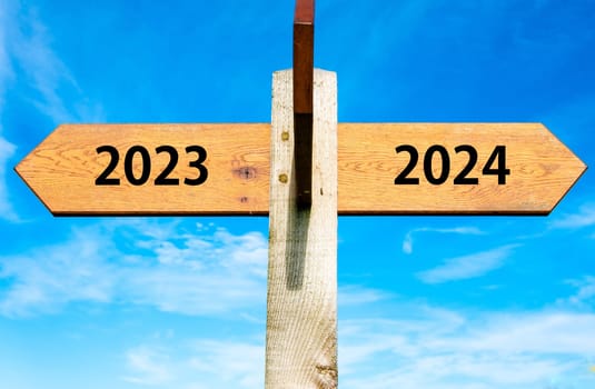 Blank wooden signpost with two arrows over clear blue sky with copy space, just add your text here