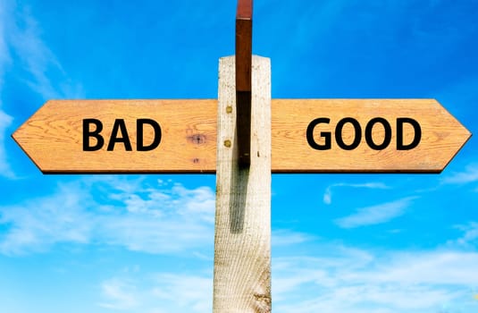 Blank wooden signpost with two arrows over clear blue sky with copy space, just add your text here
