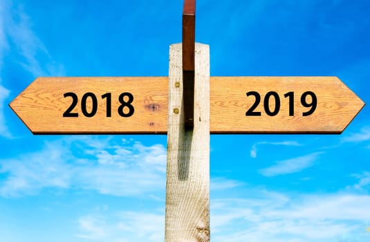 Blank wooden signpost with two arrows over clear blue sky with copy space, just add your text here