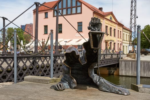 KLAIPEDA, LITHUANIA - JULY 05, 2017: The Black Ghost bronzed sculpture (designed by Svajunas Jurkus and Sergejus Plotnikovas). Danes river quay. Klaipeda Old Town residential district. Lithuania