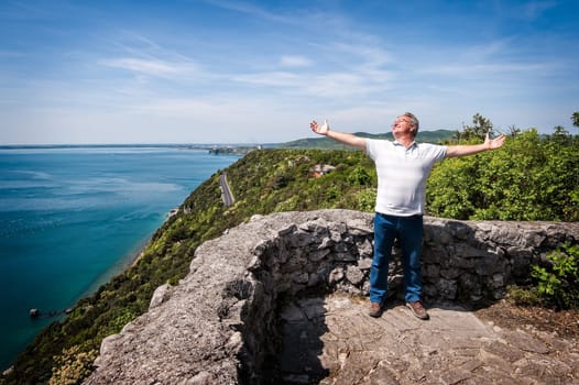 Conceptual image with very happy mature man in nature background.  Happiness for the holiday or travel.  Happiness of being finally retired