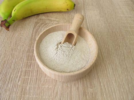 Banana flour from green plantains in a wooden bowl