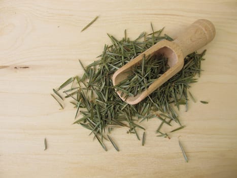 Dried juniper needles on a wooden board