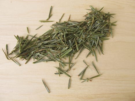 Dried juniper needles on a wooden board