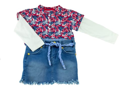 Fashionable little girl shirt with floral print and a blue jeans skirt for children.  Concept summer fashion for childs.