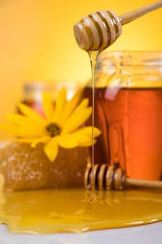 Honey jar, flower with dipper and flowing honey