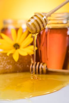 Honey jar, flower with dipper and flowing honey